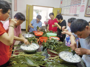 港越社区干部与居民一起包粽子。